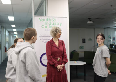 Three student council members standing with Nina Taylor MP in the school's break-out space