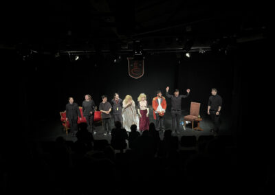 Cracked Actors students and staff standing on stage at the end of the play receiving an applause