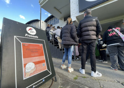 Youth2Industry College students and community members queuing to go inside the Cracked Actors Theatre