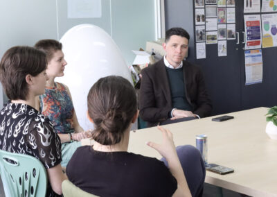 Ryan Batchelor MP sitting around a table with Youth2Voice students during a Q&A session